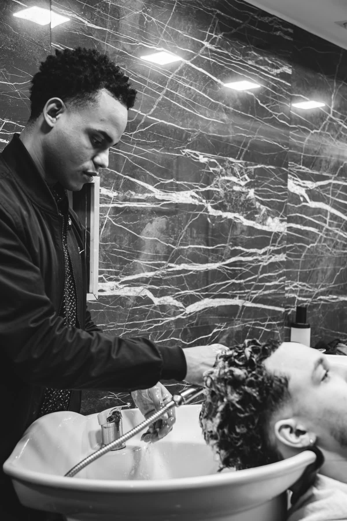 Lavagem do cabelo antes do corte, no lavatório de mármore da Cutz Lab
